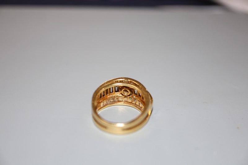 A modern yellow metal and three row diamond set dress ring, size J, gross 7 grams, set with round and baguette cut stones.